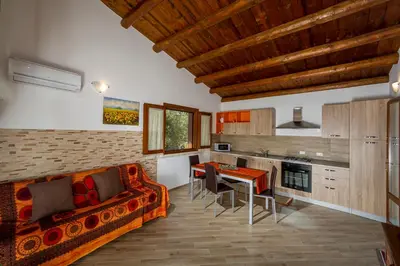 a living room with a couch and a table at Casetta degli Ulivi Castellammare del Golfo in Scopello