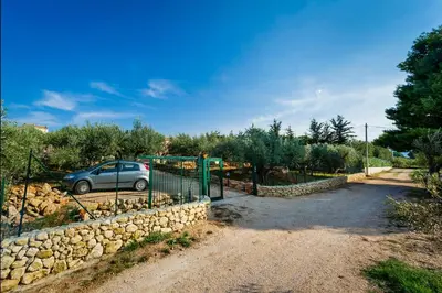 a car parked next to a stone wall at Casetta degli Ulivi Castellammare del Golfo in Scopello