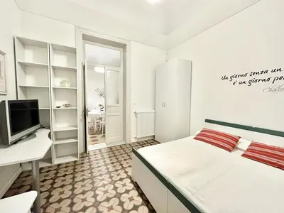 a bedroom with a bed and a desk and a tv at PALAZZO LA ZAGARA in Palermo