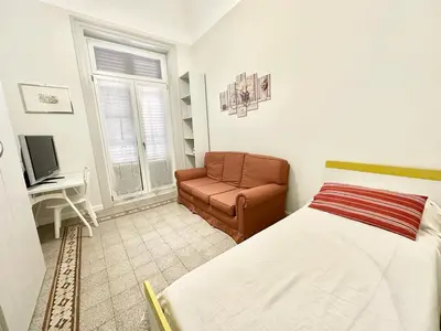 a bedroom with a bed and a couch and a desk at PALAZZO LA ZAGARA in Palermo