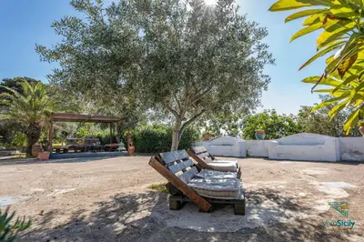 a wooden bench sitting in the middle of a park at Villa Giacona Venuti in Terrasini