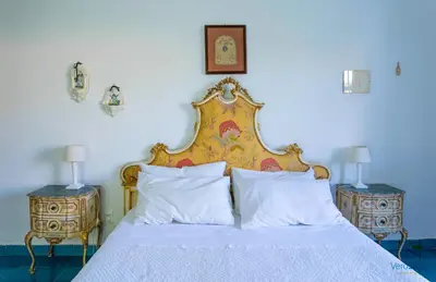 a bedroom with a bed and two night stands with lamps at Villa Giacona Venuti in Terrasini