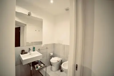 a white bathroom with a sink and a toilet at Palermo Inn Studios in Palermo