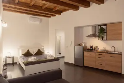 a bedroom with a bed and a refrigerator in it at Palermo Inn Studios in Palermo