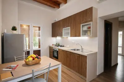 a kitchen with a table and a sink and a refrigerator at Palermo Inn Studios in Palermo