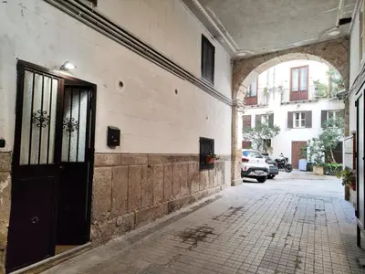an alley with a black door on a building at CASETTA SPECIALE in Palermo