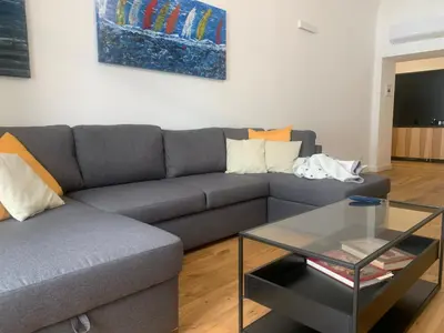 a living room with a gray couch and a glass table at Cala nera Luxury Apartment in Palermo
