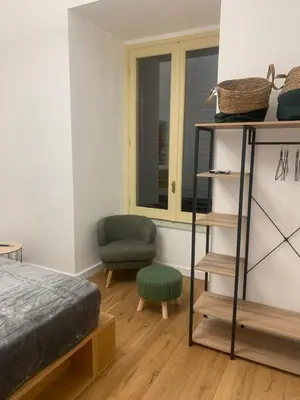 a bedroom with a bed and a chair and a shelf at Cala nera Luxury Apartment in Palermo