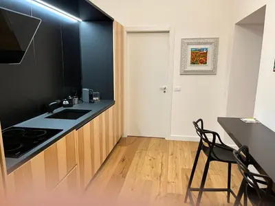 a kitchen with a black counter and a table and chairs at Cala nera Luxury Apartment in Palermo