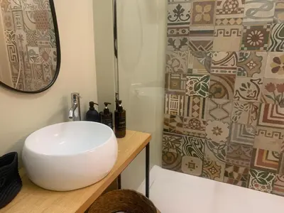 a bathroom with a white sink and a shower at Cala nera Luxury Apartment in Palermo