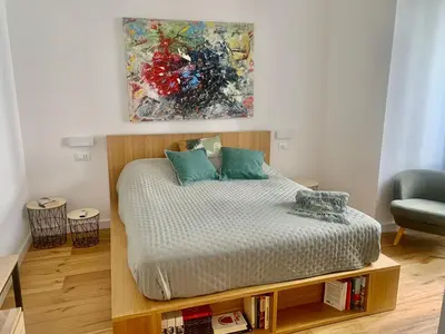 a bedroom with a bed and a painting on the wall at Cala nera Luxury Apartment in Palermo