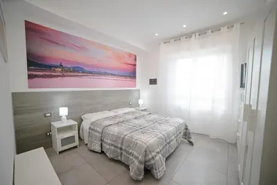 a bedroom with a bed and a painting on the wall at City Life in Palermo
