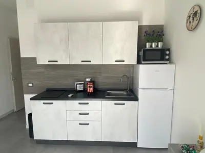 a kitchen with white cabinets and a sink and a microwave at City Life in Palermo