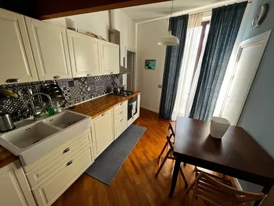 a kitchen with white cabinets and a table and a dining room at A casa del Conte in Palermo