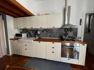 a kitchen with white cabinets and a stove top oven at A casa del Conte in Palermo