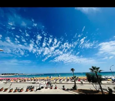 a beach with a lot of umbrellas and the ocean at Casa Conturrana,10 metri dalla spiaggia di San Vito in San Vito lo Capo