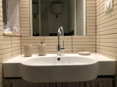 a white sink in a bathroom with a mirror at Siandri House in Palermo