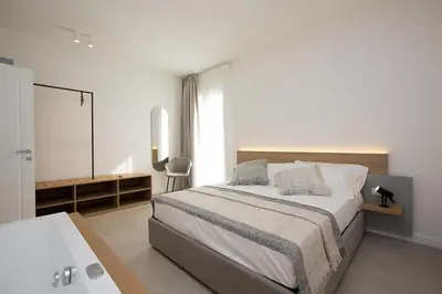 a bedroom with a bed and a desk and a tv at Giada Luxury Terrasini in Terrasini