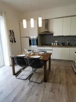 a kitchen with a wooden table and some chairs at Dagnino House - Luxury apartment in the center of Palermo in Palermo