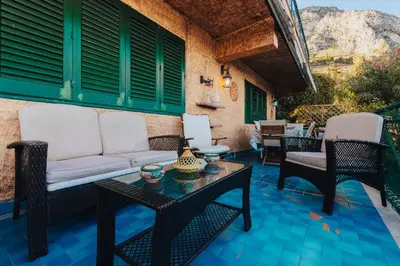 a patio with a couch and chairs and a table at Monia beach house in Santa Flavia