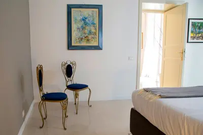two chairs sitting next to a bed in a bedroom at Cassari 61 in Palermo