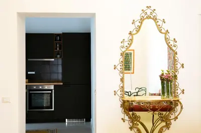 a kitchen with black and white walls and a gold mirror at Cassari 61 in Palermo