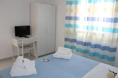 a bedroom with a bed and a desk and a television at Villa Nàmali just 100 meters from the sea !!! in Trappeto