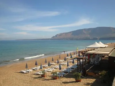 a beach with umbrellas and chairs and the ocean at Villa Nàmali just 100 meters from the sea !!! in Trappeto