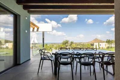 a dining room with a table and chairs and a large window at Villa vista mare Piscina e SPA in Castellammare del Golfo