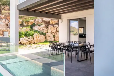 a patio with a table and chairs and a swimming pool at Villa vista mare Piscina e SPA in Castellammare del Golfo