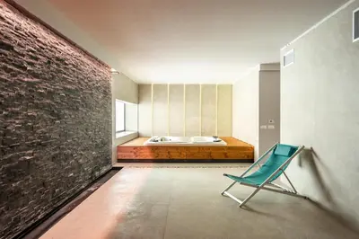 a green chair in a room with a bed at Villa vista mare Piscina e SPA in Castellammare del Golfo