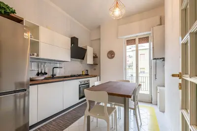 a kitchen with white cabinets and a wooden table at Casa Lincoln by Wonderful Italy in Palermo