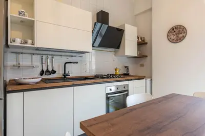 a kitchen with white cabinets and a wooden table at Casa Lincoln by Wonderful Italy in Palermo