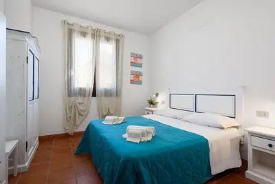 a bedroom with a large bed with a blue blanket at Casa Serena in San Vito lo Capo