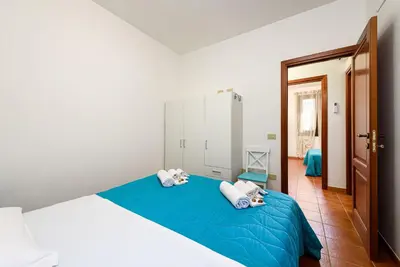 a bedroom with a blue bed with two pillows at Casa Serena in San Vito lo Capo