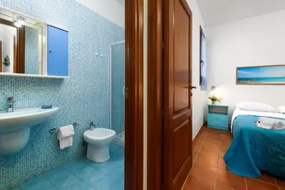 a bathroom with a sink and a toilet and a sink at Casa Serena in San Vito lo Capo