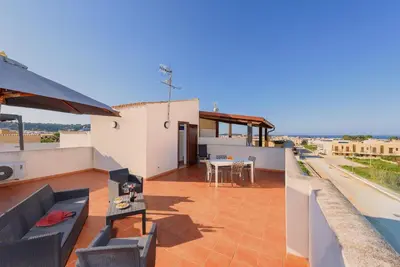 a balcony of a house with a table and chairs at Casa Serena in San Vito lo Capo