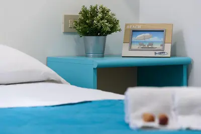 a blue table with a plant on top of a bed at Casa Serena in San Vito lo Capo