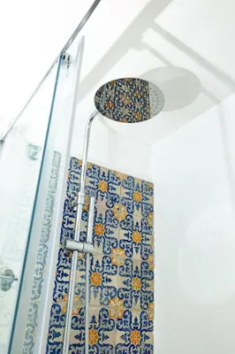 a shower with blue and white tiles on the wall at Casa Gagini in Palermo