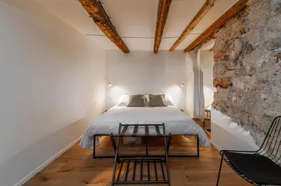 a bedroom with a bed and a stone wall at Casa Gagini in Palermo