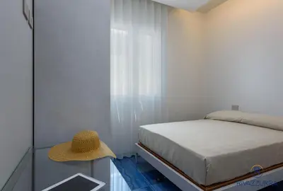 a bedroom with a bed and a straw hat on a table at Rivazzurra Beach Rooms in San Vito lo Capo
