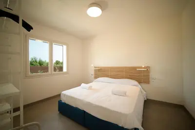 a bedroom with a bed and a window at Blu Home Scopello in Castellammare del Golfo