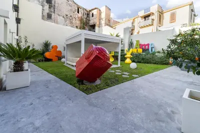 a garden with a red object in the middle of a yard at Casa Slide a Palermo in Palermo