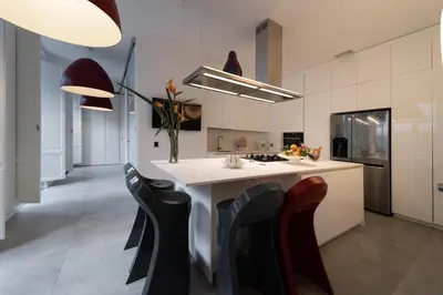 a kitchen with black chairs and a white counter at Casa Slide a Palermo in Palermo
