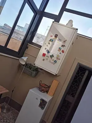 a kitchen with a refrigerator in a room with windows at Casa Allegra in Palermo