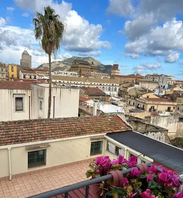 a view of a city from a balcony with pink flowers at mialuxuryhouse in Palermo