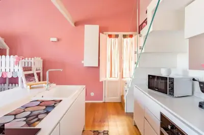 a kitchen with pink walls and white cabinets and a sink at mialuxuryhouse in Palermo