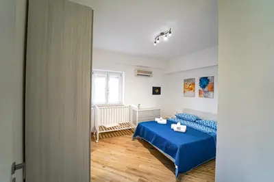 a bedroom with a blue bed and a window at Lovely Villa, close to the beach in Palermo