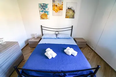 a bedroom with a blue bed with towels on it at Lovely Villa, close to the beach in Palermo