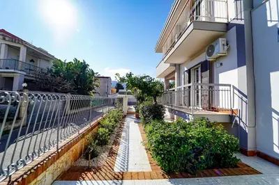 an alley between two buildings with a fence and plants at Lovely Villa, close to the beach in Palermo